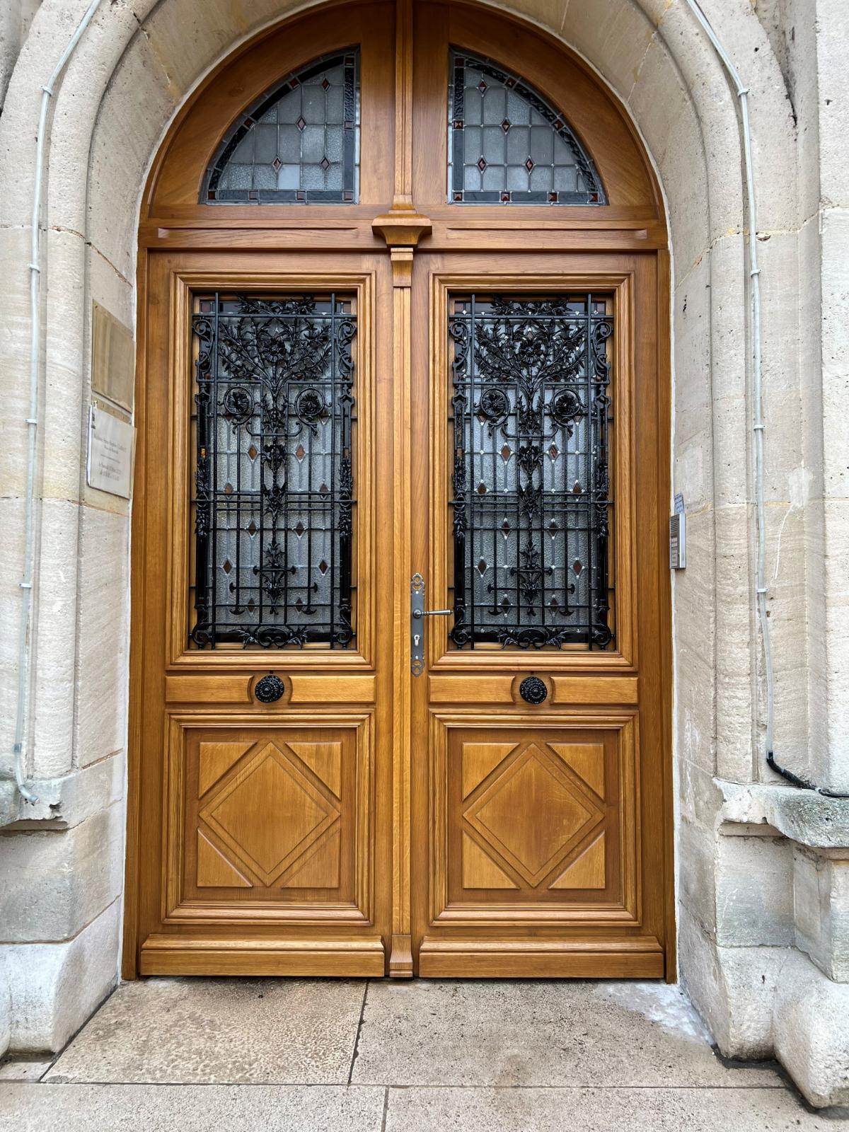 Porte en bois avec une fenêtre vitrée et une poignée en laiton