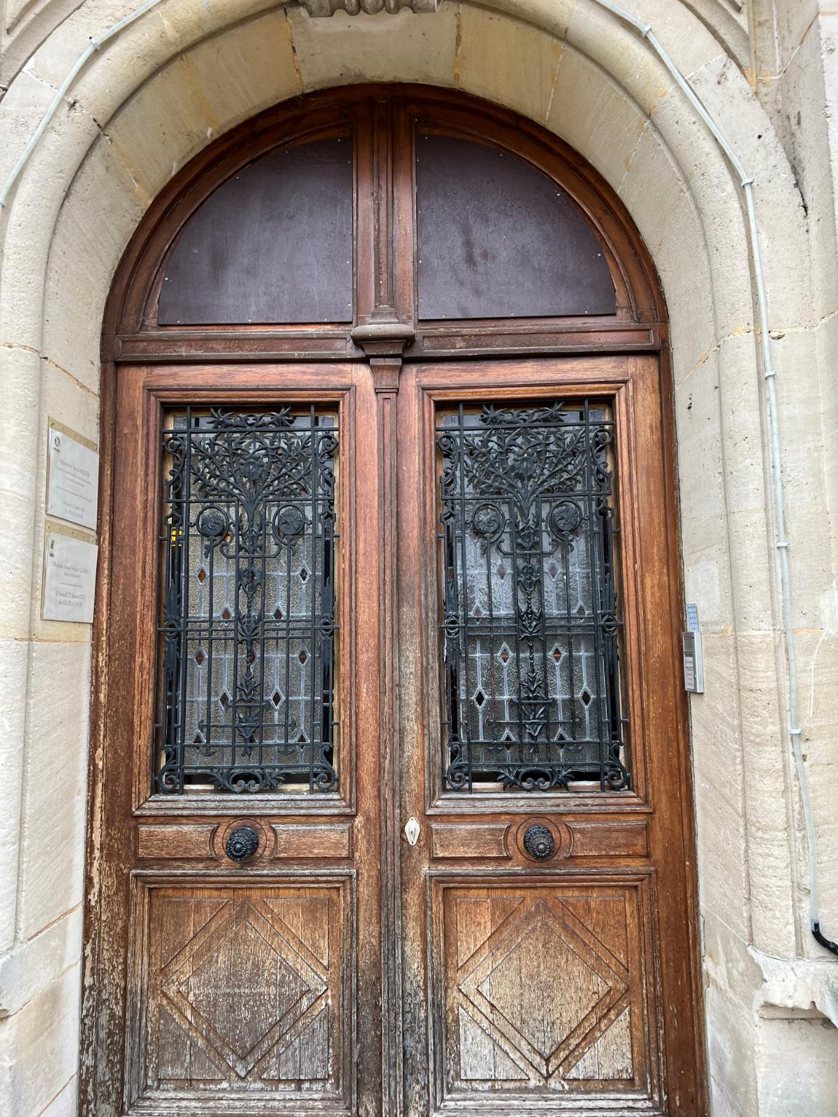 Porte en bois avec des vitraux et un cadre en pierre