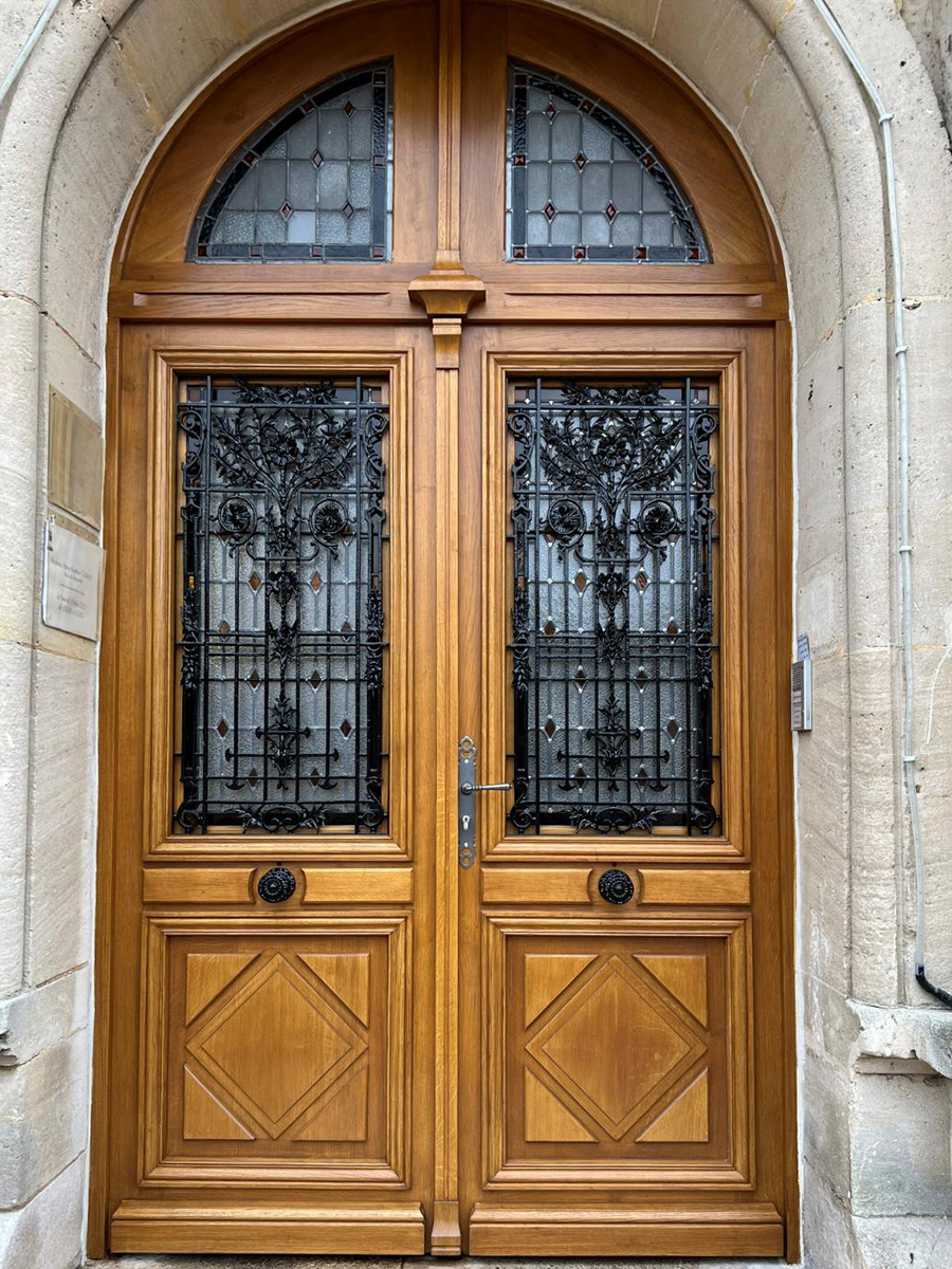 Porte en bois avec une fenêtre vitrée et une poignée en laiton